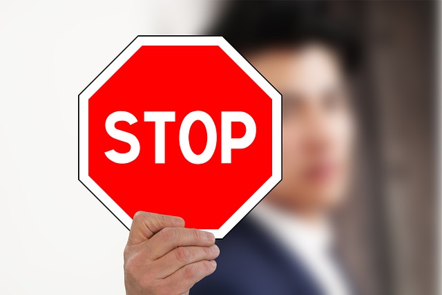 businessman holding stop sign